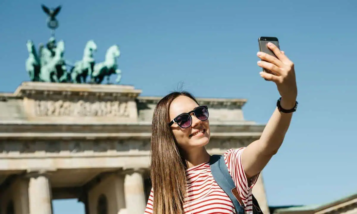 Woman making selfie in front of Branderburger Tor, Berlin, Germany