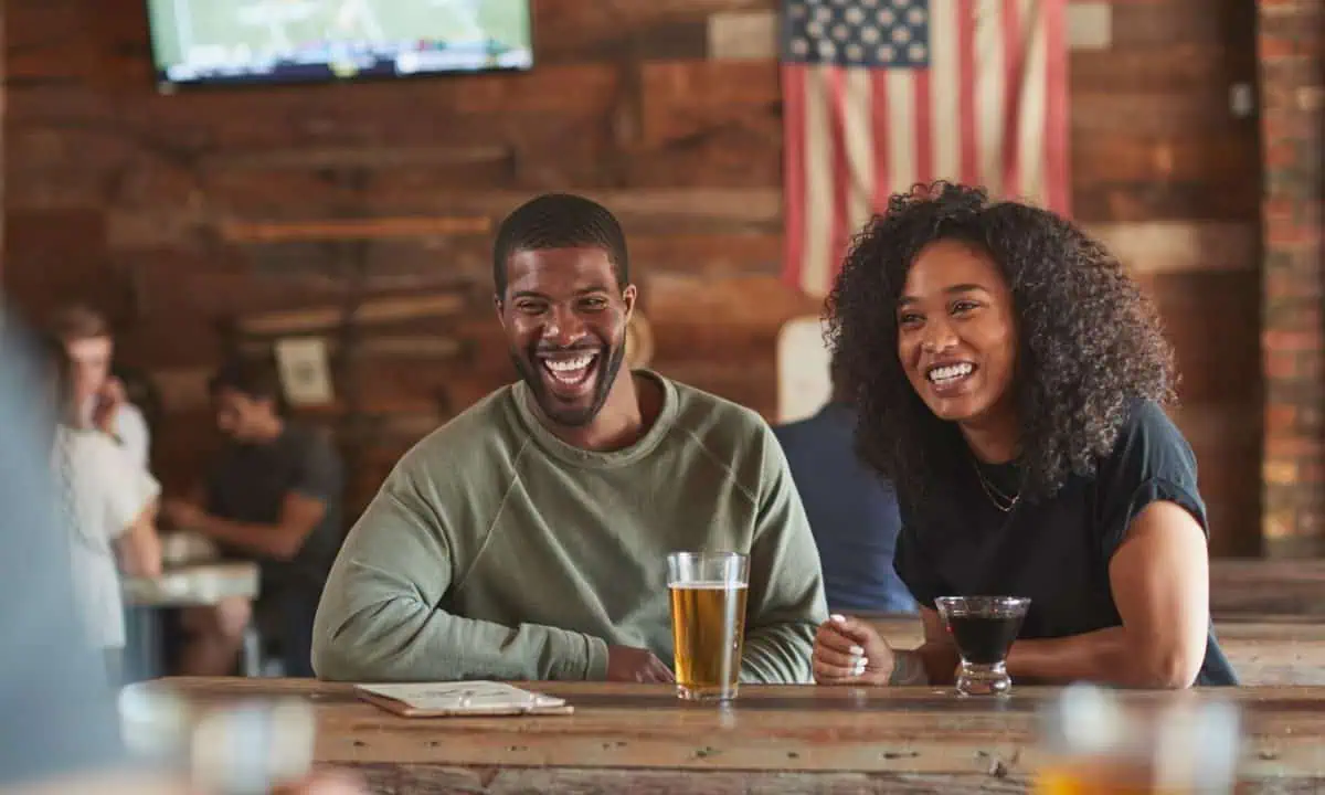 Young couple meeting in sports bar drinking